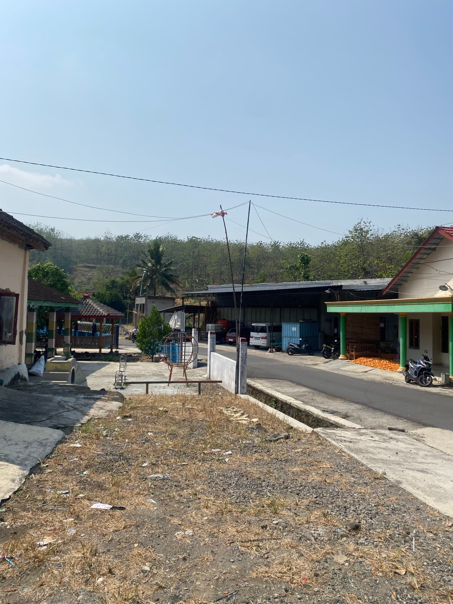Permukiman warga dengan perbukitan hutan di latar belakang